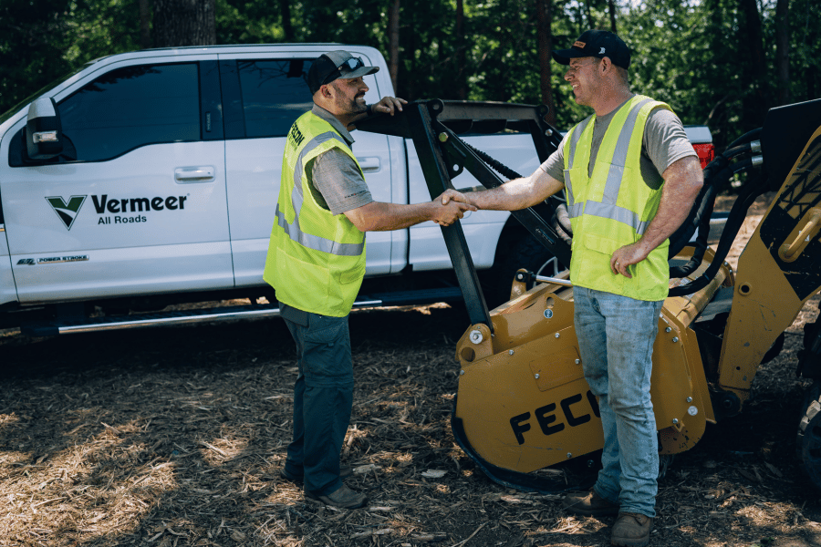 Sales Rep from Vermeer All Roads shaking hands with FECON machine operator